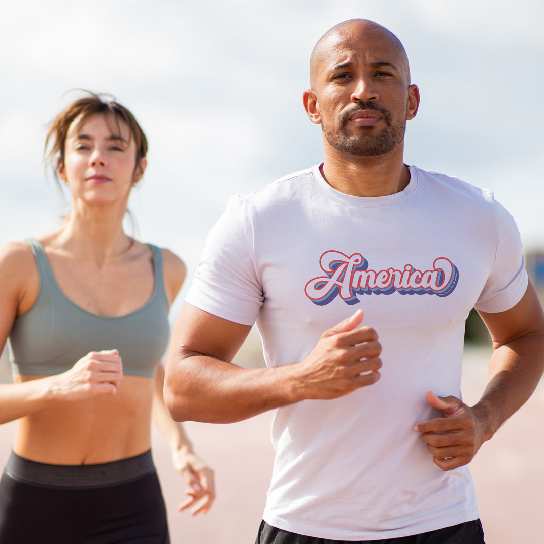 Man and woman running outdoors White t-shirt with 'America' text in colorful design on a white background