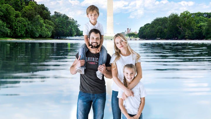 A family of four posing together in front of a Washington Monument backdrop. The father wears a Black t-shirt by America The Beautiful with &