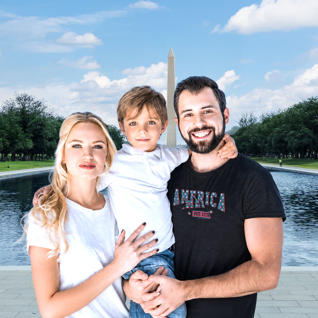 A family of four posing together in front of a Washington Monument backdrop. The father wears a Black t-shirt by America The Beautiful with &