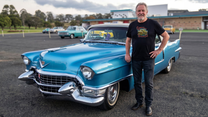 Man wearing a Black t-shirt with colorful graphic of vintage Cadillac and &