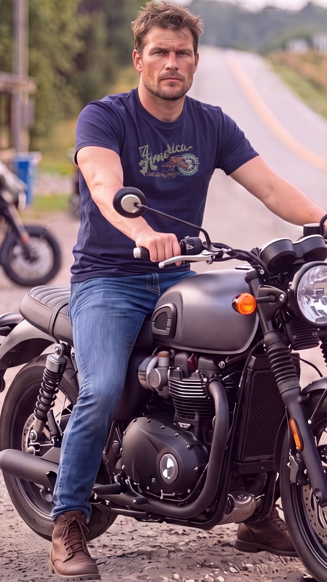 A man riding a motorcycle on a country road, wearing a Navy blue t-shirt with &