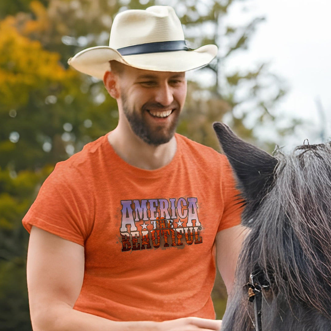 Mean on horse wearing Orange t-shirt with 'America the Beautiful' text design over a monument valley design