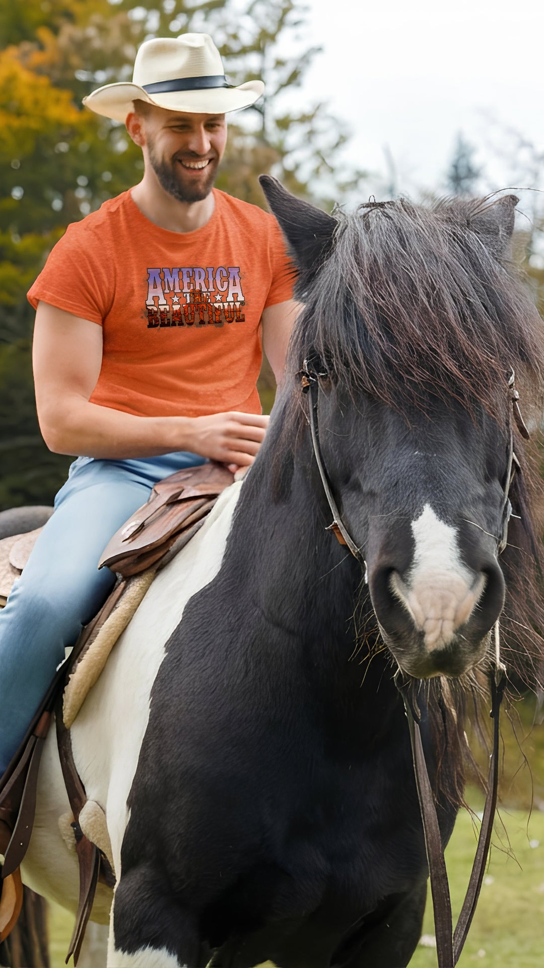 Man in an orange shirt riding a horse in a natural setting