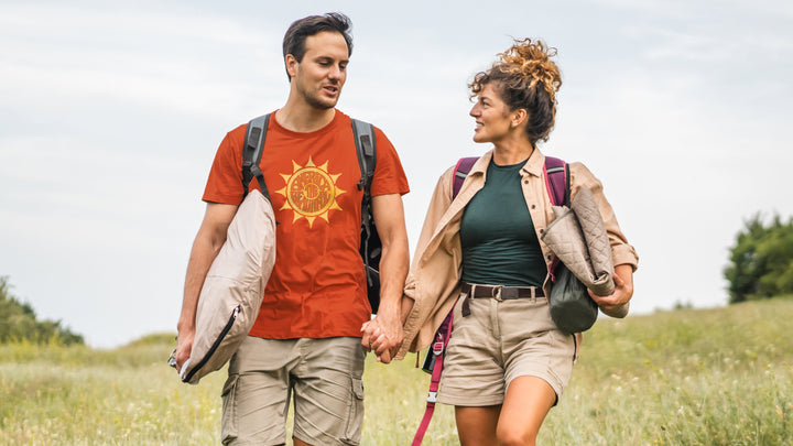 A couple walking in nature with the man wearing an America The Beautiful "awesome Sun" orange shirt