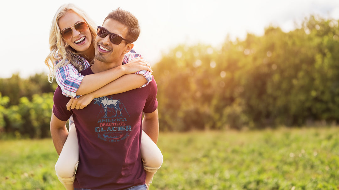 Man carrying a woman Maroon t-shirt with a moose graphic and &