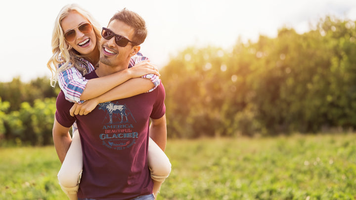 Man carrying a woman Maroon t-shirt with a moose graphic and &