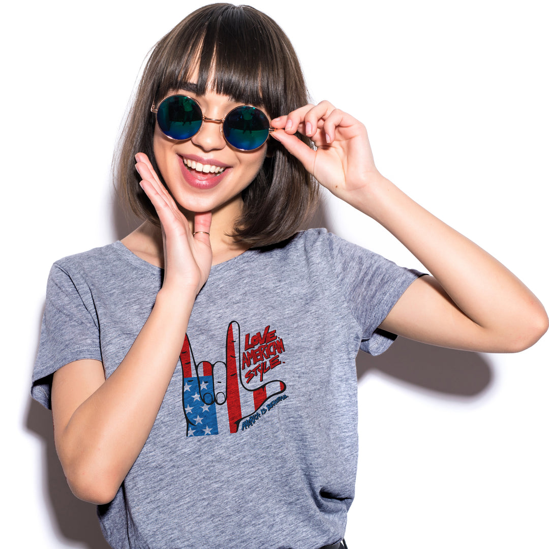 Woman wearing a Gray t-shirt with a graphic design of hands making a "I love you" shape and text