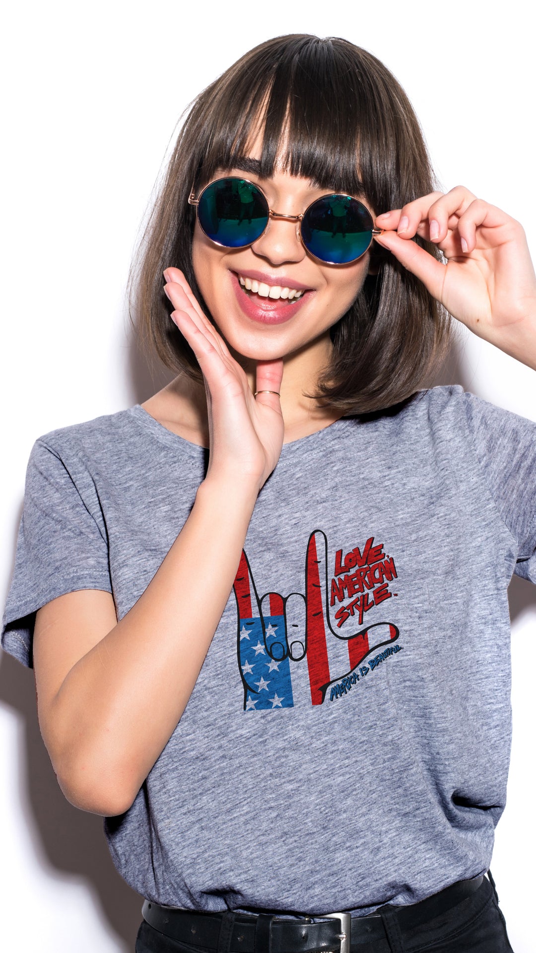 Woman wearing a Gray t-shirt with a graphic design of hands making a "I love you" shape and text
