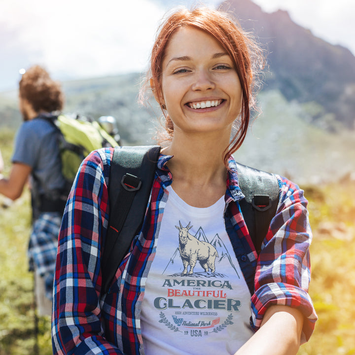 Woman hiker wearing White t-shirt with graphic design of a mountain goat and Glacier park text