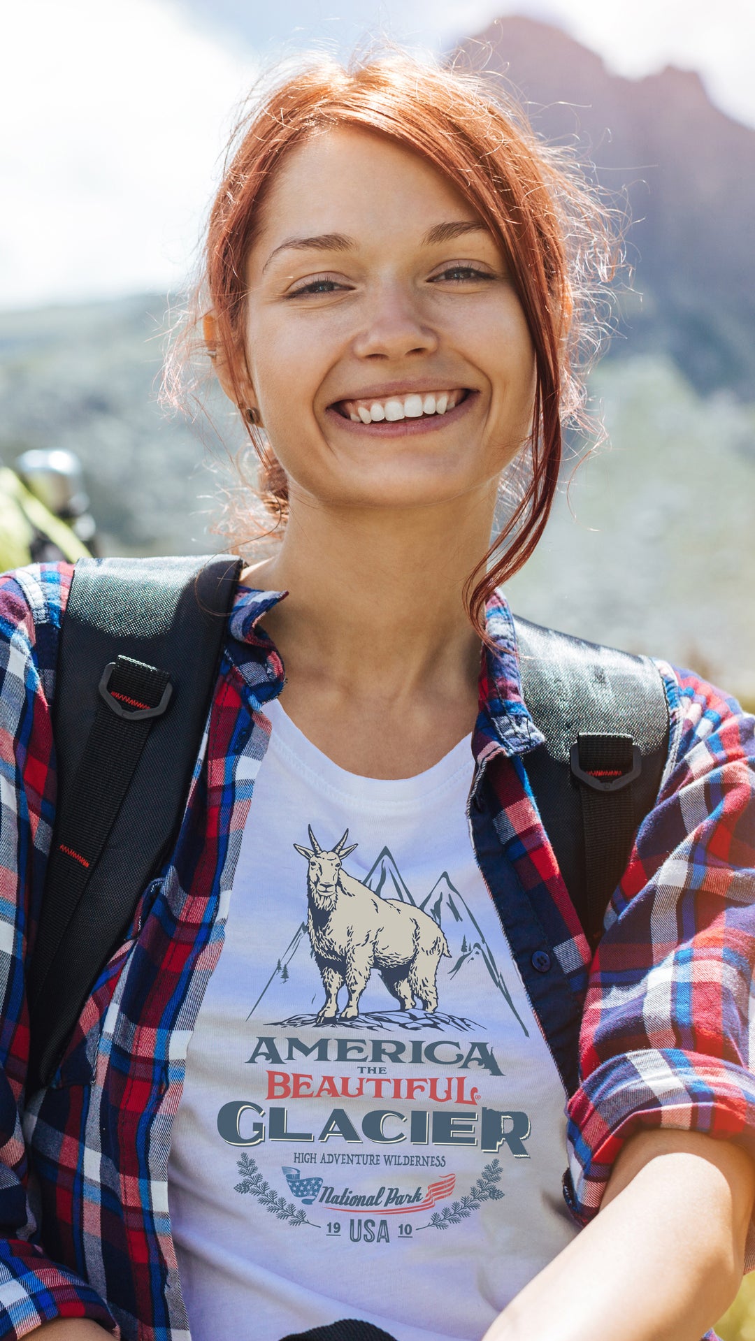 Woman hiker wearing White t-shirt with graphic design of a mountain goat and Glacier park text