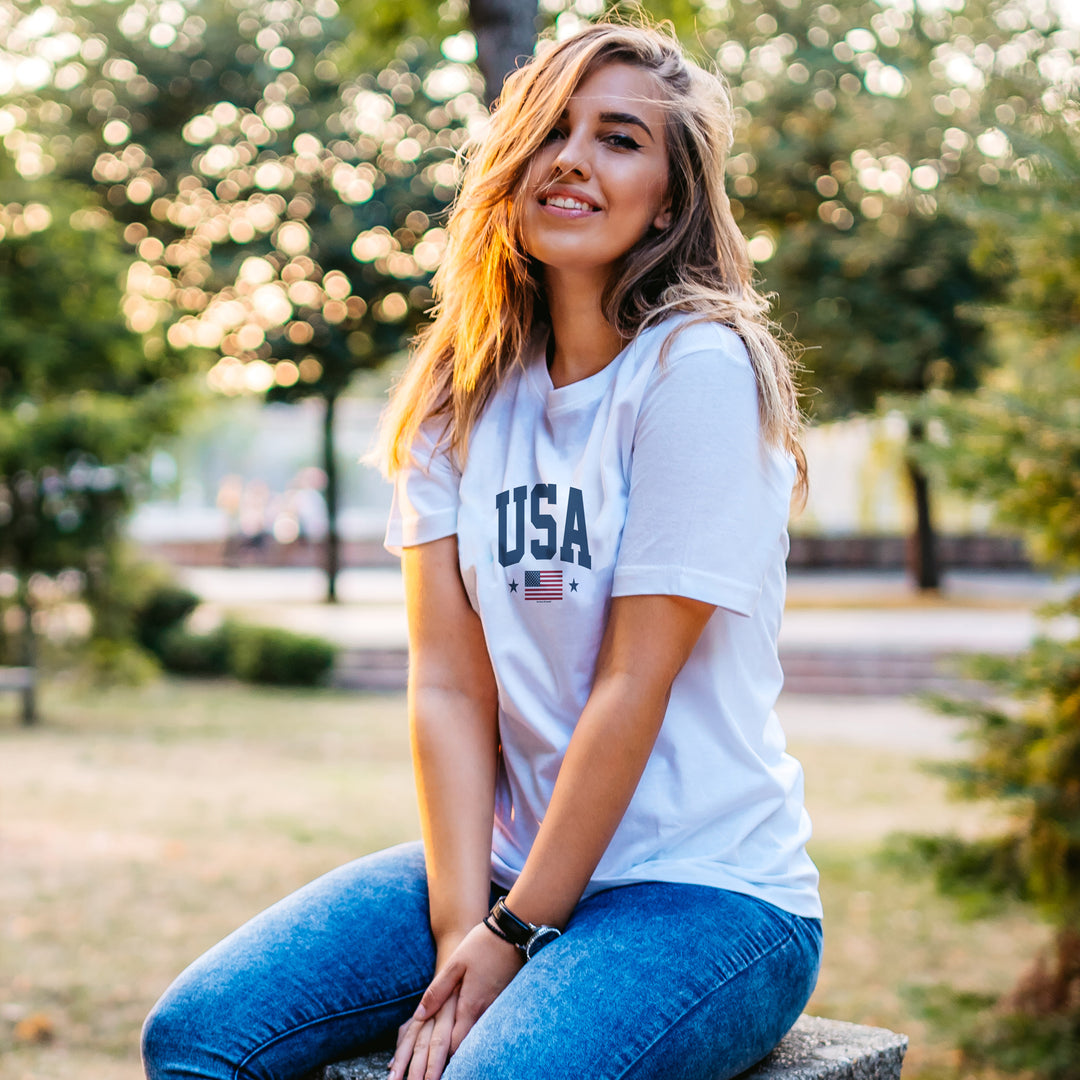 Woman wearing a White t-shirt with 'USA' and American flag design on a white background