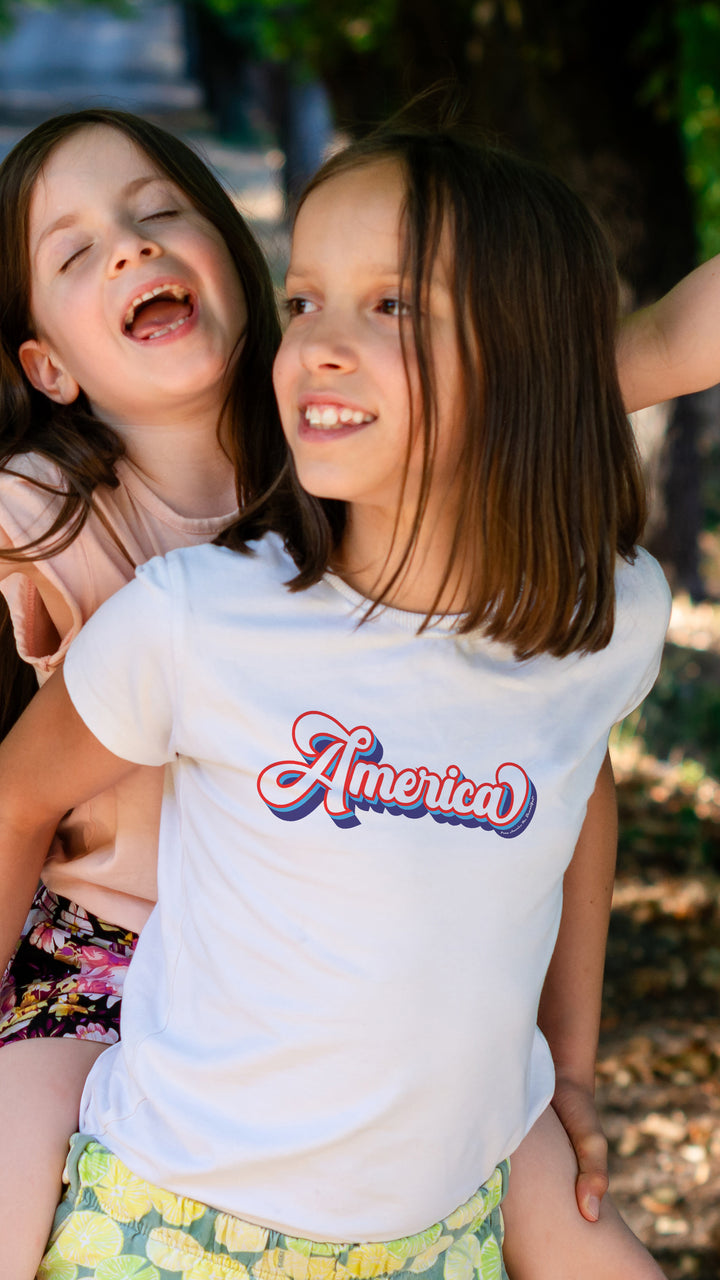 Two young girls, one wearing a &