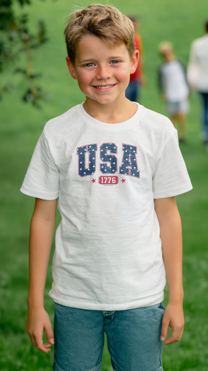 Young boy wearing a white t-shirt with &