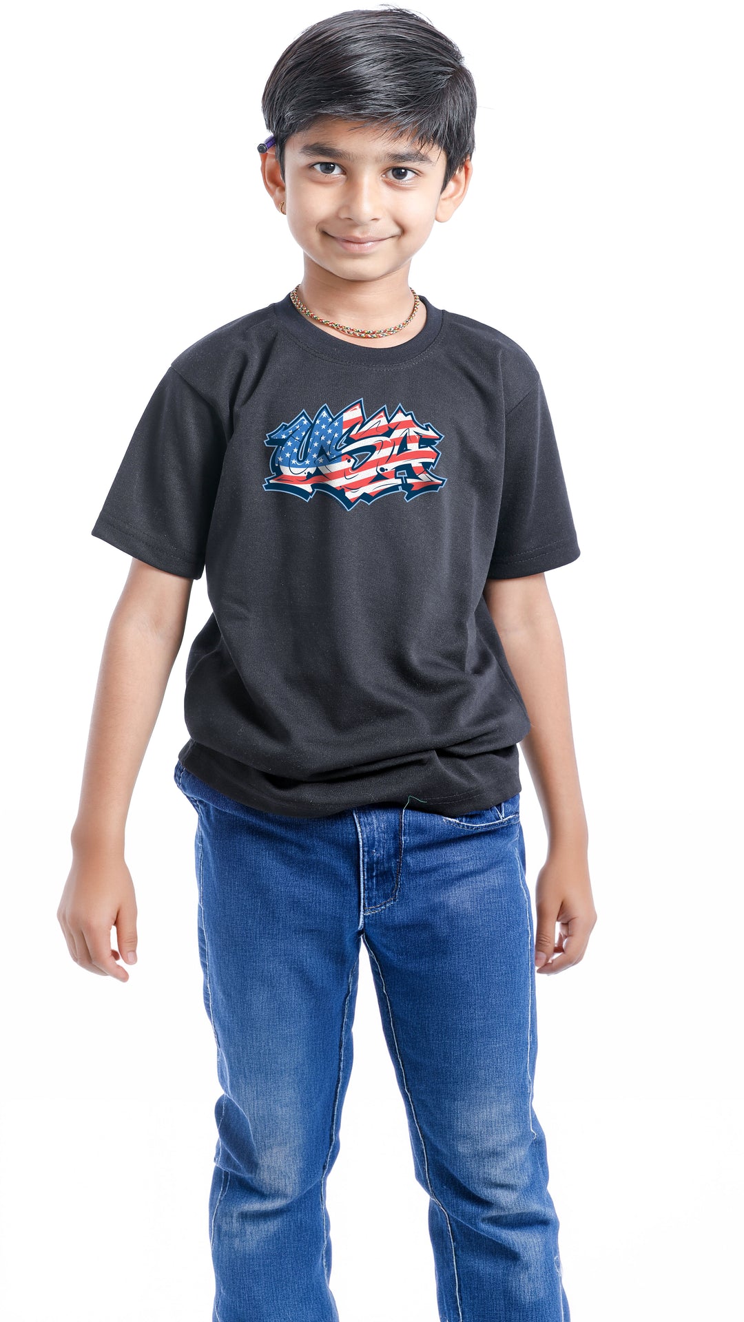 Child wearing a black t-shirt with an American flag design and blue jeans on a white background